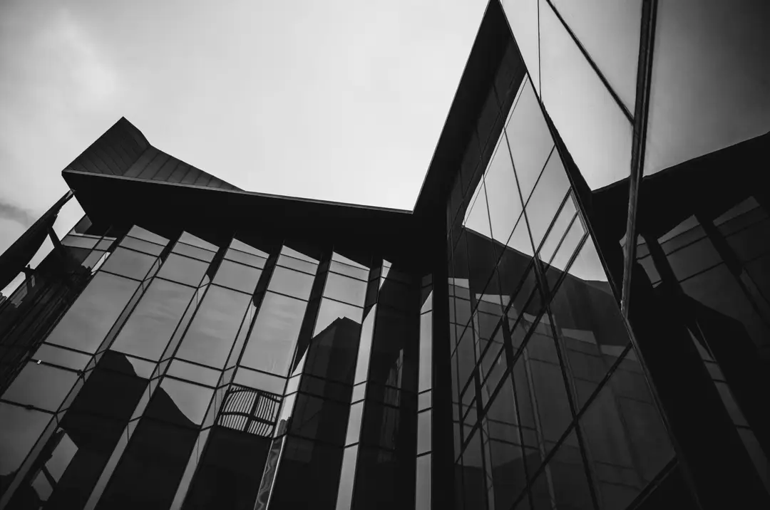 Black and white view looking up at a glass office tower